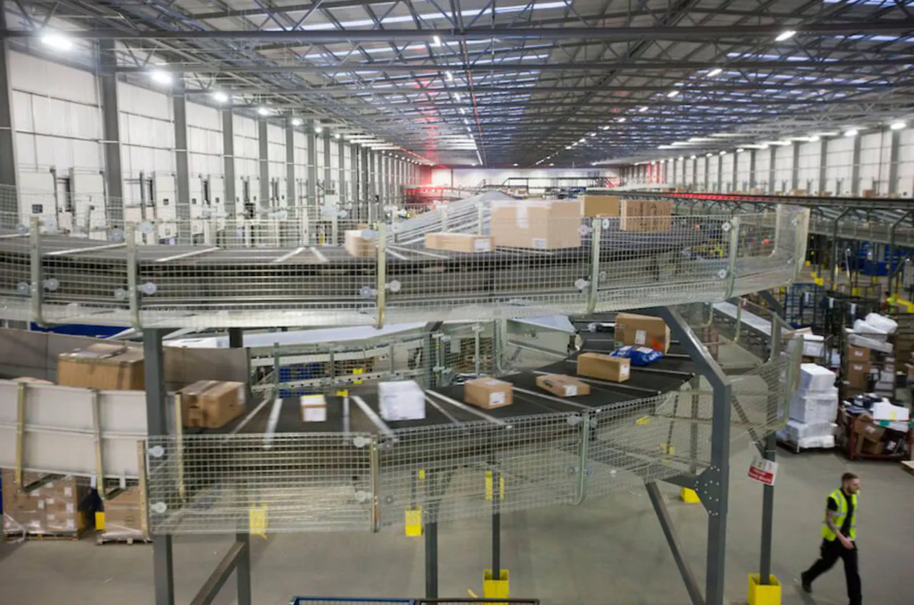 A cross-belt sorter loop processing parcels in a distribution center